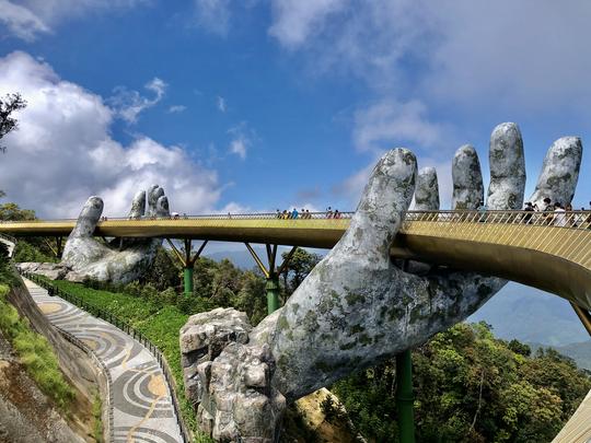 Goldene Brücke, die von zwei steinernen Händen gehalten wird