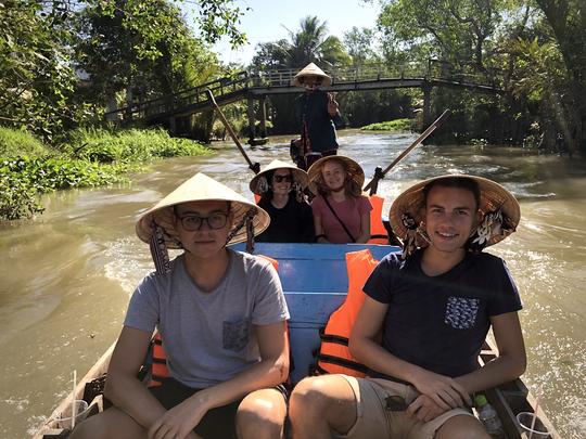 Die Reisegruppe am Boot mit Reishüten